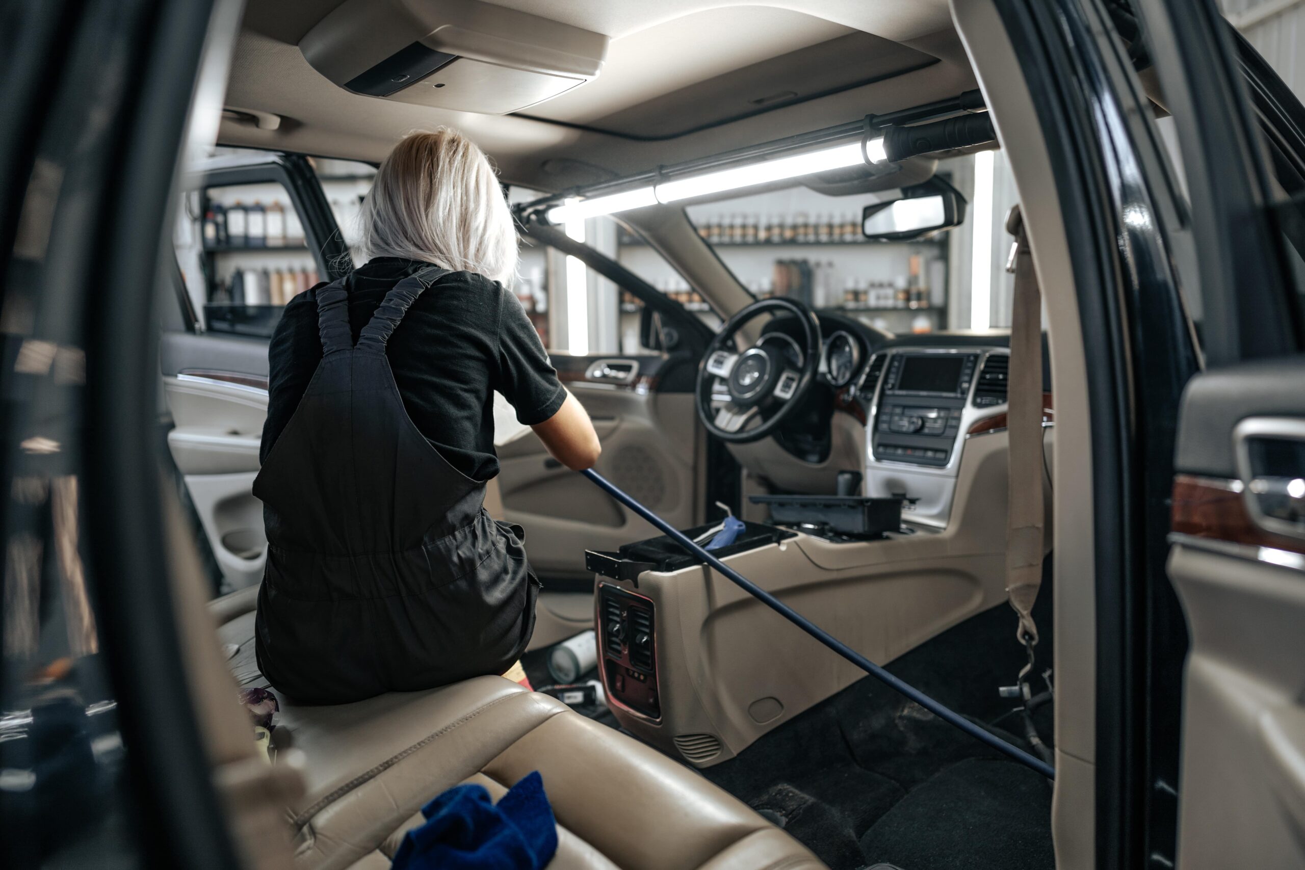 Woman doing interior restoration of a vehicle.